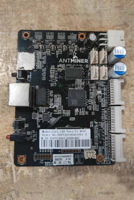 Antminer control board by WeMine featuring detailed microchips, connectors, and identification labels on a wooden background, symbolizing advanced cryptocurrency mining technology.